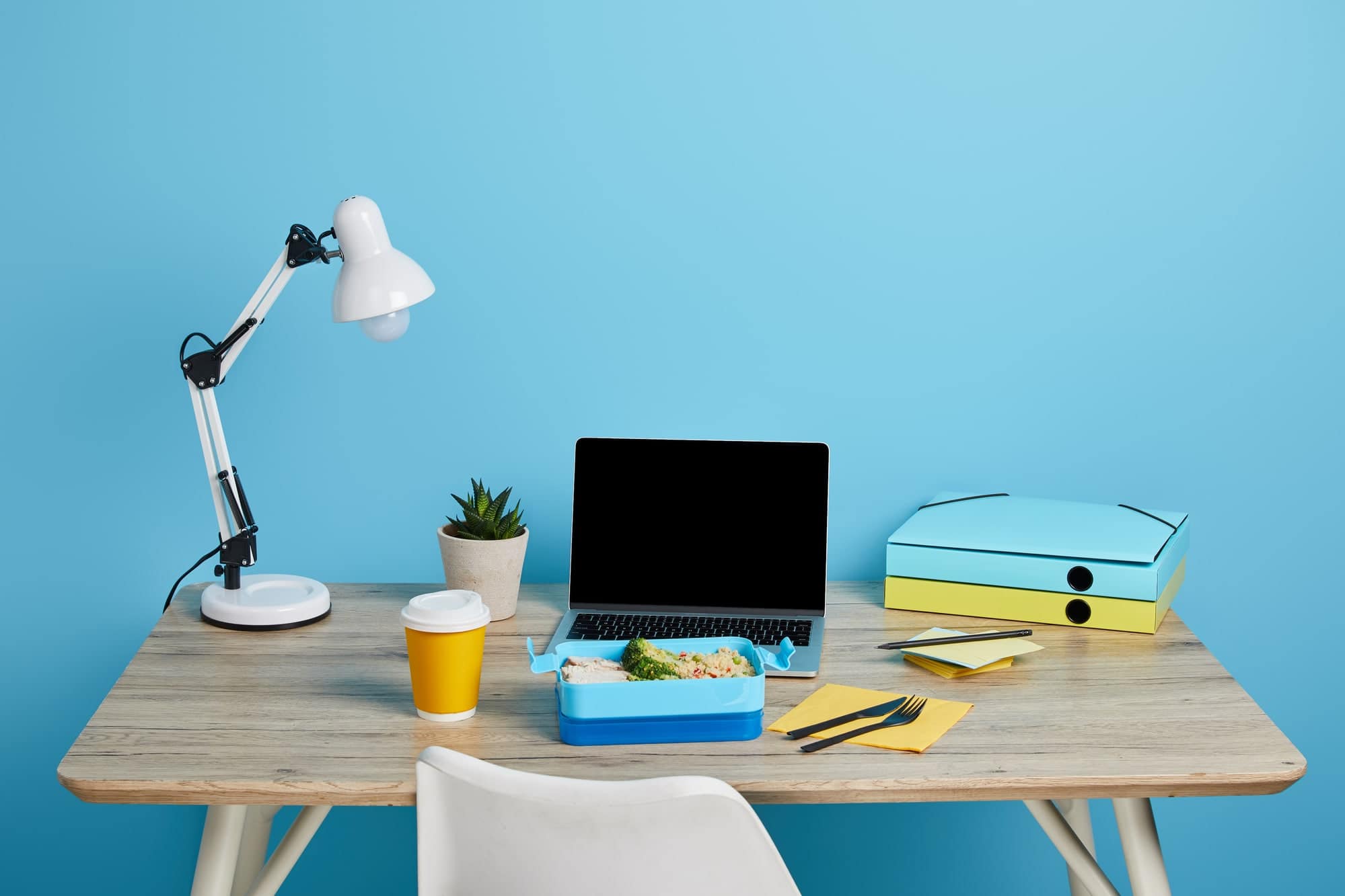 laptop on desk with blue background - earn free gift cards
