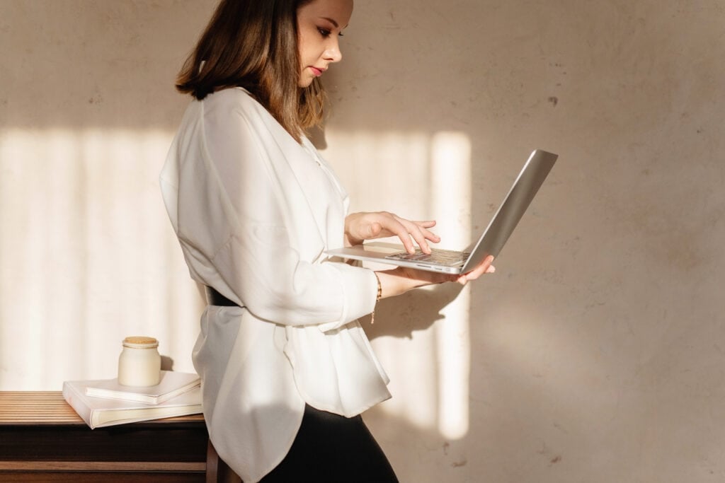 woman holding laptop for article about where to publish short stories online